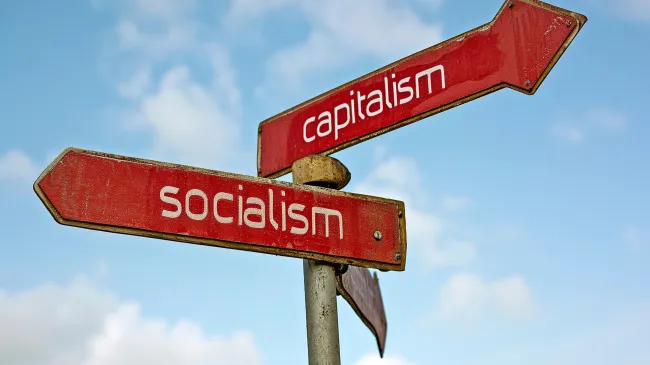 crossroad with socialism and capitalism road signs